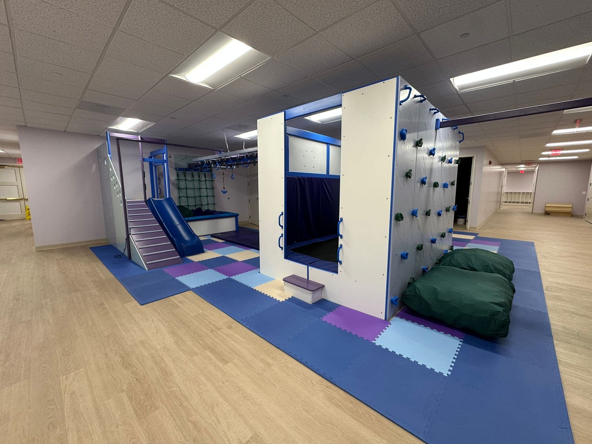 Wide view of a commercial sensory gym with climbing walls