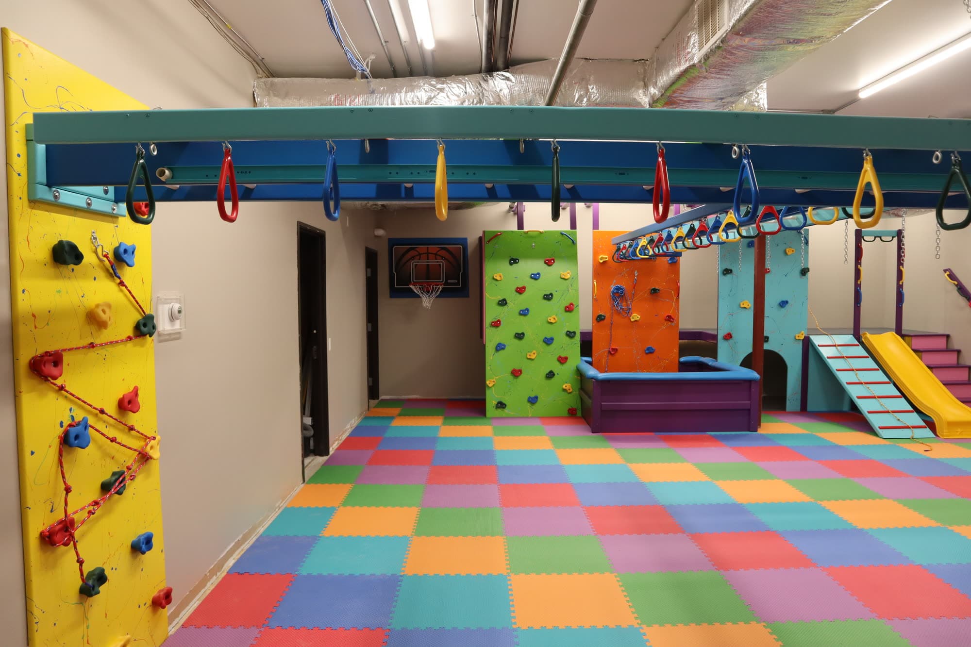 Colorful home sensory gym installation with rainbow equipment