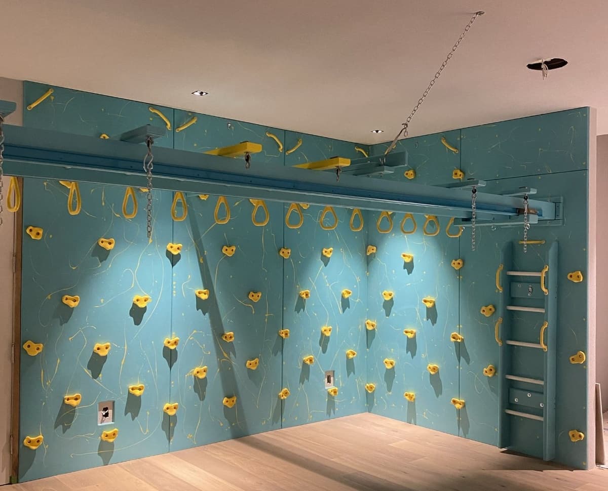 Completed home sensory gym with teal climbing wall